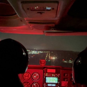 Night cockpit approach with runway lights ahead